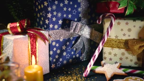 Traditionele details van gezellige kerst - brandende gouden kaars met geschenken, sparren takken, peperkoek koekjes en lolly 's. Feestelijke winterviering. Prettige feestdagen concept. — Stockvideo