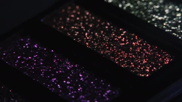 Närbild av ögonskuggor färgglada glitter palett - kosmetika för ögon. Skönhet reklam, make-up artist instrument koncept. Makrodetaljerade bilder. — Stockvideo