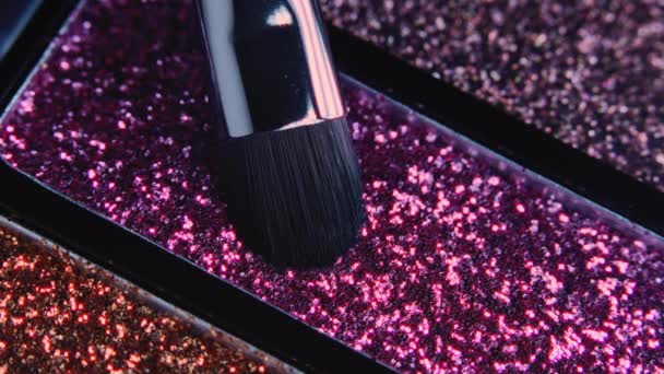 Makro syn på makeup artist arbetar med ögonskugga glitter palett. Borsta vinner glitter på hög. Arbetsprocess, verktyg inom skönhetsindustrin. Reklamprodukter, kosmetika koncept. — Stockvideo