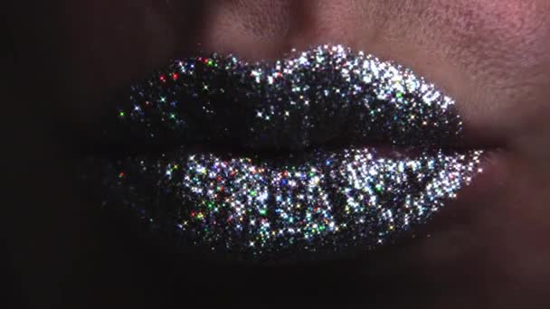 カメラにエアキスを送る唇に光沢のある輝きを持つセクシーなファッションモデル。グラマラスなメイクアップを持つ女性のマクロビュー。ナイトライフナイトクラブのコンセプト. — ストック動画