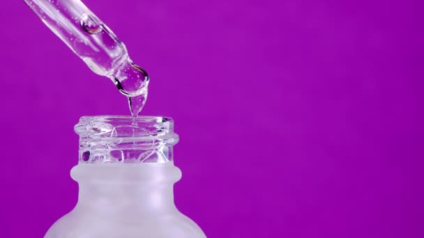 Υαλουρονικό οξύ ορού στάζει από πιπέττα σε παγωμένο γυάλινο βάζο. Έννοια της ενυδάτωσης, υγιεινή περιποίηση προσώπου, καλλυντικά προϊόντα, έξυπνη τάση κατανάλωσης. Ροζ φόντο στούντιο. Αντιγραφή χώρου — Αρχείο Βίντεο