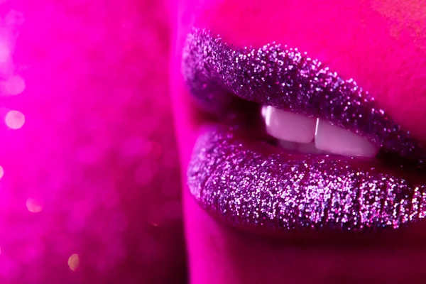 Fashion model met glanzende glitters op mollige lippen. Roze neon studiolampje. Macro uitzicht op vrouw met glamoureuze make-up. Nachtleven, nachtclub concept. Kopieerruimte. — Stockfoto