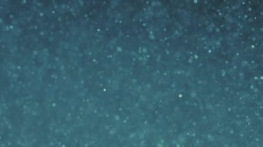 Parlak mavi bokeh ışıltılarıyla soyut bir arka plan. Parlayan Parçacıklar. Odaklanamayan dairesel fakül. Doğal yüzen organik soyut arkaplan. Noel ve Mutlu Yıllar.