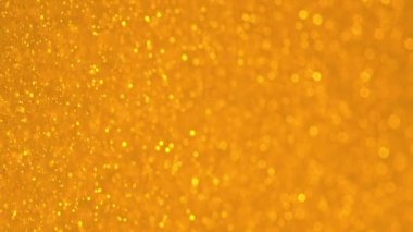 Bokeh 'le parıldayan Altın Parçacıklar. Sarı altın çözünmüş dairesel fakül. Doğal Yüzen Organik Soyut Parçacıklar. Geçmişi. Noel ve Mutlu Yıllar. Yavaş çekim.