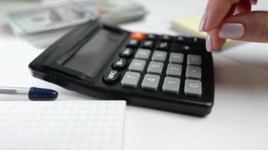 Hesap makinesindeki tuşlara basan kadın finans uzmanı şirket harcamalarını analiz ediyor. Kadın hesaplamalar yapıyor. Konut kredisi, yatırım, ekonomi, tasarruf parası veya sigorta kavramı.