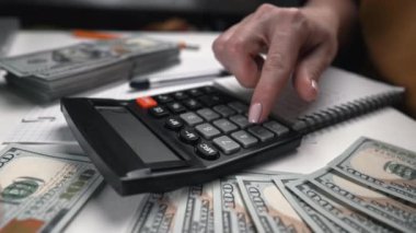 Tanımlanamayan kadın eski muhasebe hesap makinesinin klavyesine güveniyor. El ile basma, ev bütçesi tutma, ev ofisinden harcama planlama..