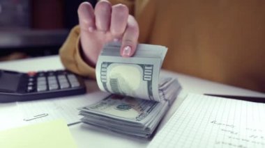 Kadın merkez büroda 100 dolar nakit sayıyor. Büyük para birimi, finans ve yatırım konsepti. Yavaş çekim.