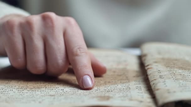 Vrouw die het oude boek leest - Bijbel. Geconcentreerd volgt aandachtig vinger op vinger op papier pagina in de bibliotheek. Oude archiefmanuscripten. Historisch concept. — Stockvideo