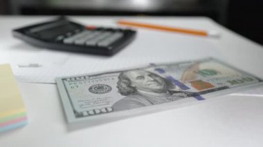Kadın dolar sayıyor. Kadın muhasebeci ya da bankacı merkez büroda Amerikan para birimini sayar. Elinde yeni banknotlar var. İzleme finans, bütçe, tasarruf ve gider kavramı.