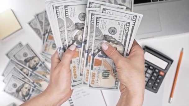 Γυναίκα καταμέτρηση των ΗΠΑ νόμισμα στο σπίτι τραπέζι με φόντο υπολογιστή. Η γυναίκα μετράει δολάρια - χρήματα. Νέα τραπεζογραμμάτια σε χέρια. — Αρχείο Βίντεο