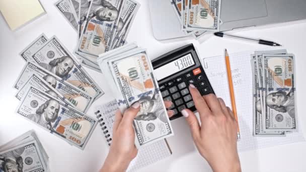 Nerozpoznatelná žena drží peníze v rukou a počítá příjem z kalkulačky. Sledování domácího rozpočtu a výdajů. Účetní nebo bankéř pracuje - pohled shora. — Stock video
