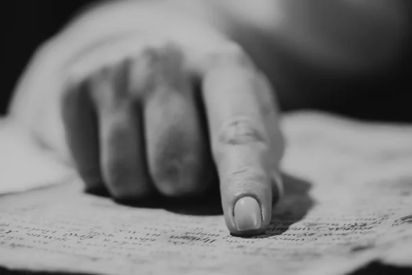 Frau liest altes Buch - Bibel. Konzentriert folgt Finger auf Papierseite in der Bibliothek. Alte Archivhandschriften. Geschichtskonzept. — Stockfoto