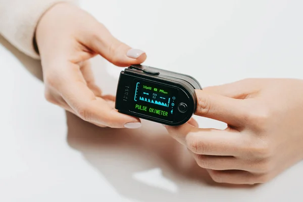 Woman put on pulse oximeter on finger, check blood oxygen saturation. Monitoring heart rate at home during pandemic coronavirus covid-19 — Stock Photo, Image