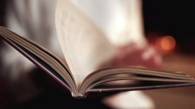 Sayfalarca kağıda göz atan bir kadın. Romantik bir bayan. Kız şöminenin yanında oturuyor ve eski edebiyattan bilgi arıyor.. 