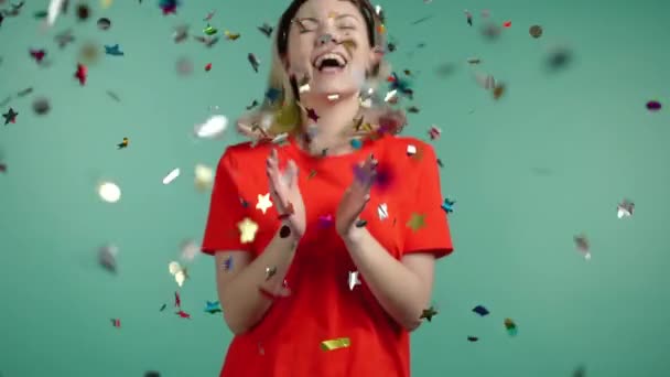 흥분 한 여자는 박수갈채를 보내고 재미를 느끼며 녹색 스튜디오 에 있는 콘 페티 비에 대해 기뻐하고 있다. 축하, 파티, 승소의 개념. — 비디오