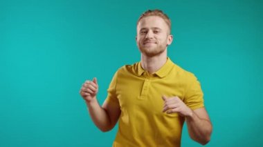 Sarışın adam mavi stüdyo arka planında dans ediyor. Yakışıklı erkek model adam. Parti, mutluluk, özgürlük, gençlik kavramı.