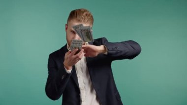 Mutlu yüzlü bir iş adamı para saçıyor. Adam aşırı para harcıyor. Adamın mavi stüdyo geçmişinde dolarlar var..