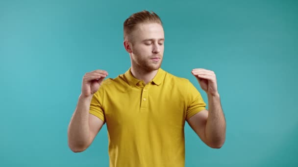 Handsome bored man showing bla-bla-bla gesture with hands and rolling eyes isolated on blue background. Empty promises, blah concept. Lier — Stock Video