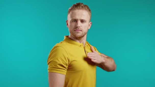 Self-confident young man hits in chest, guy is proud of himself, how cool he is and can do anything. Selfishness, arrogance concept. Blue studio background. — Stock Video