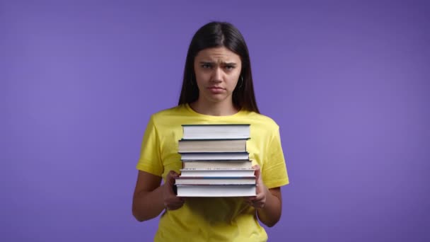 La donna europea annoiata come studente è insoddisfatta della quantità di compiti e libri. È infastidita, scoraggiata e frustrata dagli studi. Violet studio sfondo — Video Stock