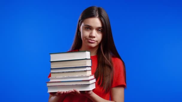 European bored woman as student is dissatisfied with amount of homework and books. She is annoyed, discouraged frustrated by studies. Blue studio background — Stock Video