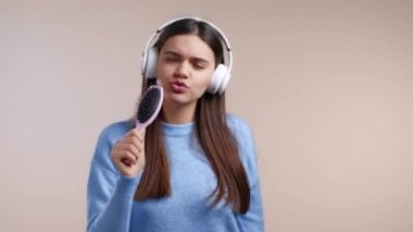 Güzel bir kadın saç fırçasıyla şarkı söyleyip dans ediyor ya da mikrofon yerine bej duvarda mikrofon kullanıyor. Kulaklıklı kız eğleniyor, müzik dinliyor, ünlü olma hayalleri kuruyor..