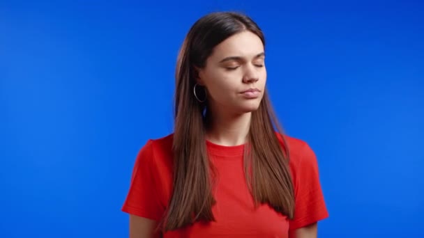 Onflexibele vrouw keurt het af zonder hoofdteken, knikt afkeurend met het hoofd. Ontkennen, Afwijzen, Oneens, Portret van mooi meisje op blauwe studio achtergrond. — Stockvideo