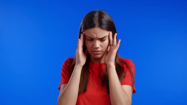 Baş ağrısı çeken bir kadının portresi, mavi stüdyo resmi. Ellerini başının üstüne koyan bir kız. Migren sorunları, ilaç, hastalık kavramı — Stok video