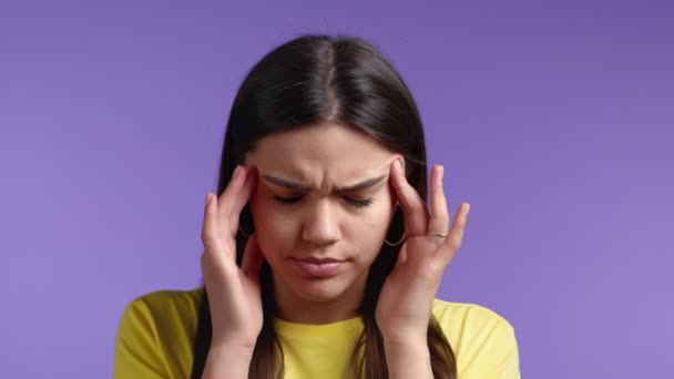 Retrato de mujer con dolor de cabeza, retrato de estudio violeta. Chica poniendo las manos en la cabeza. Concepto de problemas de migraña, medicina, enfermedad — Vídeos de Stock