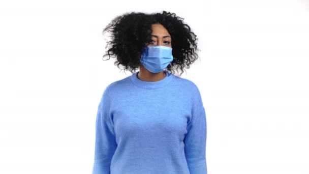 顔の保護マスクの顔の保護マスクの柔軟性のないアフリカの女性は、頭のサインなしで不承認、鼻の頭をしぶしぶ。拒否,拒否,同意しません,白い背景に少女の肖像画.コロナウイルスの概念. — ストック動画