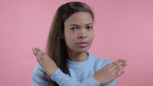 Mixed race woman disapproving with no crossing hands sign make basta, negation, enough gesture. Denying, Rejecting, Disagree, Portrait of pretty lady on pink background — Stock Video