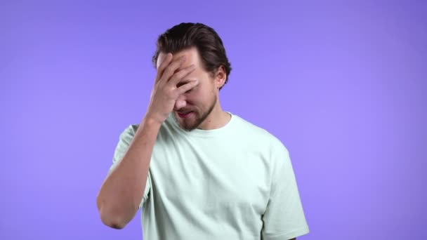 Junger Mann mit Facepalm-Geste, wie nein, habe ich vergessen. Unglücklicher Typ, der Kummer, Reue, Drama, Versagen empfindet. Er isolierte sich an der violetten Wand — Stockvideo