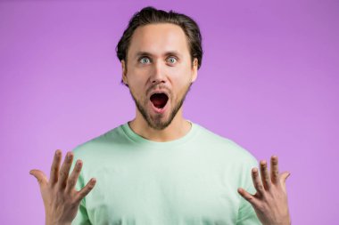 İnsan şaşkınlığı tasvir eder, zevkli yüz efektini gösterir. Şaşırmış, heyecanlı, mutlu adam. Pembe arka planda yakışıklı bir erkek model..