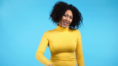 Güzel bir Afrikalı kadın saçma sapan jestler yapıyor, ciddi değil. Şaka yapıyorsun, olamaz. Kızlar mavi arka planda iltifata karşı hoş tepkiler verir.