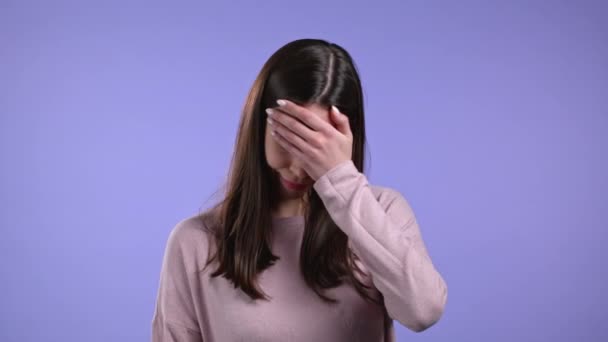 Porträt einer jungen Frau mit Facepalm-Geste, wie nein, habe ich vergessen. Unglückliche Frau mit langen Haaren, die Kummer, Reue, Drama, Versagen empfindet. Sie isolierte sich an der violetten Wand — Stockvideo