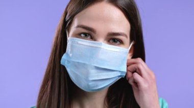 Memnun kadın koruyucu maskeyi çıkardı ve salgın hastalığın sembolü olarak yere attı. Violet stüdyo geçmişi.