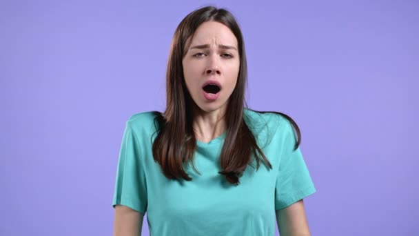 疲れて眠い女性のyawns 、手で彼女の口をカバーします。非常に退屈な、面白くない。バイオレットスタジオの背景. — ストック動画