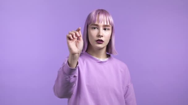 Jeune femme inhabituelle utilisant écran tactile de smartphone ou tablette. Elle glisse sur fond de studio violet. Technologie, concept d'interface. — Video