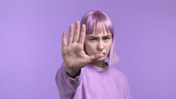 Mulher bonita desaprovando com nenhum gesto sinal de mão. Negando, rejeitando, discordando, retrato de menina bonita com cabelo roxo tingido em fundo violeta — Vídeo de Stock