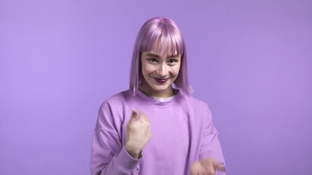 Žena ukazuje - Hej ty, pojď sem. Dívka s obarvenými fialovými vlasy požádat, aby se k ní připojil, vábí s lákavým gestem objetí rukou. Dáma vypadá hravě, flirtuje a zve mě na návštěvu. Purple studio. — Stock video