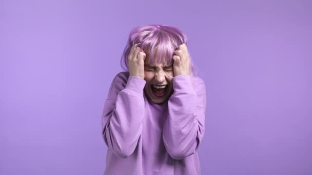 Mulher assustada e gritando com cabelo roxo tingido chocou isolado sobre fundo violeta. Estressado e deprimido menina bonita por causa de más notícias. — Vídeo de Stock