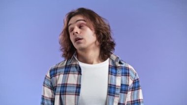 Sinirli adam iç çeker, mor arka planda yuvarlanan gözler. Hoşnutsuz Avrupalı bir adam, bu durumdan bıktı, nasıl olur da anlamazsın diye düşünüyor..