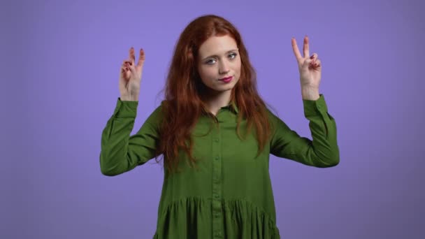 Mooie vrouw met rood haar met handen en twee vingers lucht citeert gebaar, buig vingers geïsoleerd over violette achtergrond. Geen grappig, ironisch en sarcastisch concept. — Stockvideo