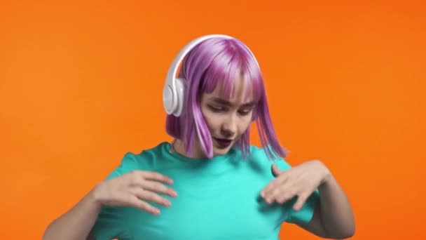 Aantrekkelijke moderne vrouw poseren met koptelefoon op blauwe studio achtergrond. Schattig meisjes portret. Muziek, radio, geluk, vrijheid, jeugdconcept. — Stockvideo