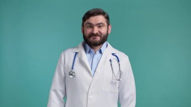 Profesyonel tıp önlüklü tatmin olmuş doktorun portresi evet işaretini kafasından gösteriyor. Adam izin veriyor, uygun şekilde muamele ediyor. Doktor adam mavi arkaplanda izole edilmiş..