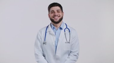 Profesyonel tıp önlüklü tatmin olmuş doktorun portresi evet işaretini kafasından gösteriyor. Adam izin veriyor, uygun şekilde muamele ediyor. Doktor stüdyoda izole edilmiş..