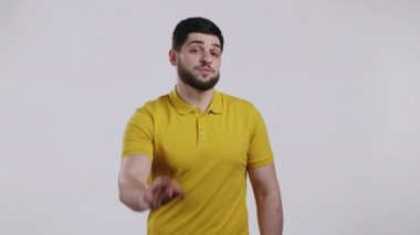 Sarı giysili yakışıklı adam tamam, tamam jest yapıyor. Beyaz arka plandaki mutlu adam. Kazandım. Başarı. Pozitif erkek model kameraya gülümser. Vücut dili. 