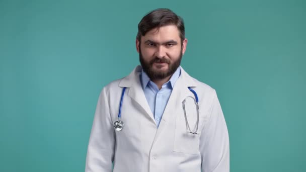 Portrait of satisfied doctor in professional medical coat showing yes sign by head. Man permits, treats approvingly. Doc man isolated on blue background. — Stock Video