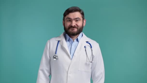 Portrét spokojeného doktora v profesionálním lékařském kabátě s nápisem "ano" po hlavě. Člověk dovolí, pochvalně zachází. Doc muž izolované na modrém pozadí. — Stock video