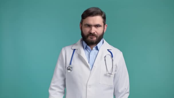Πορτρέτο του σοβαρού γιατρού σε επαγγελματική ιατρική λευκό παλτό δείχνει απόρριψη χειρονομία αποδοκιμάζει χωρίς ίχνος δακτύλου. Αρνούμαι, διαφωνώ. Γιατρός απομονωμένος σε μπλε φόντο.. — Αρχείο Βίντεο